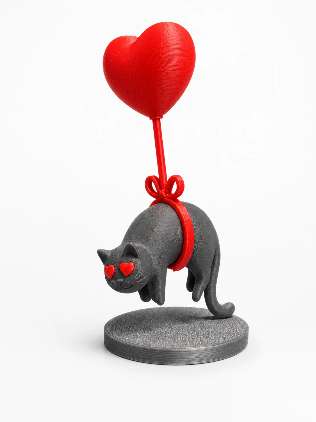 Figurine imprimée en 3D d'un chat gris suspendu à un ballon en forme de cœur rouge