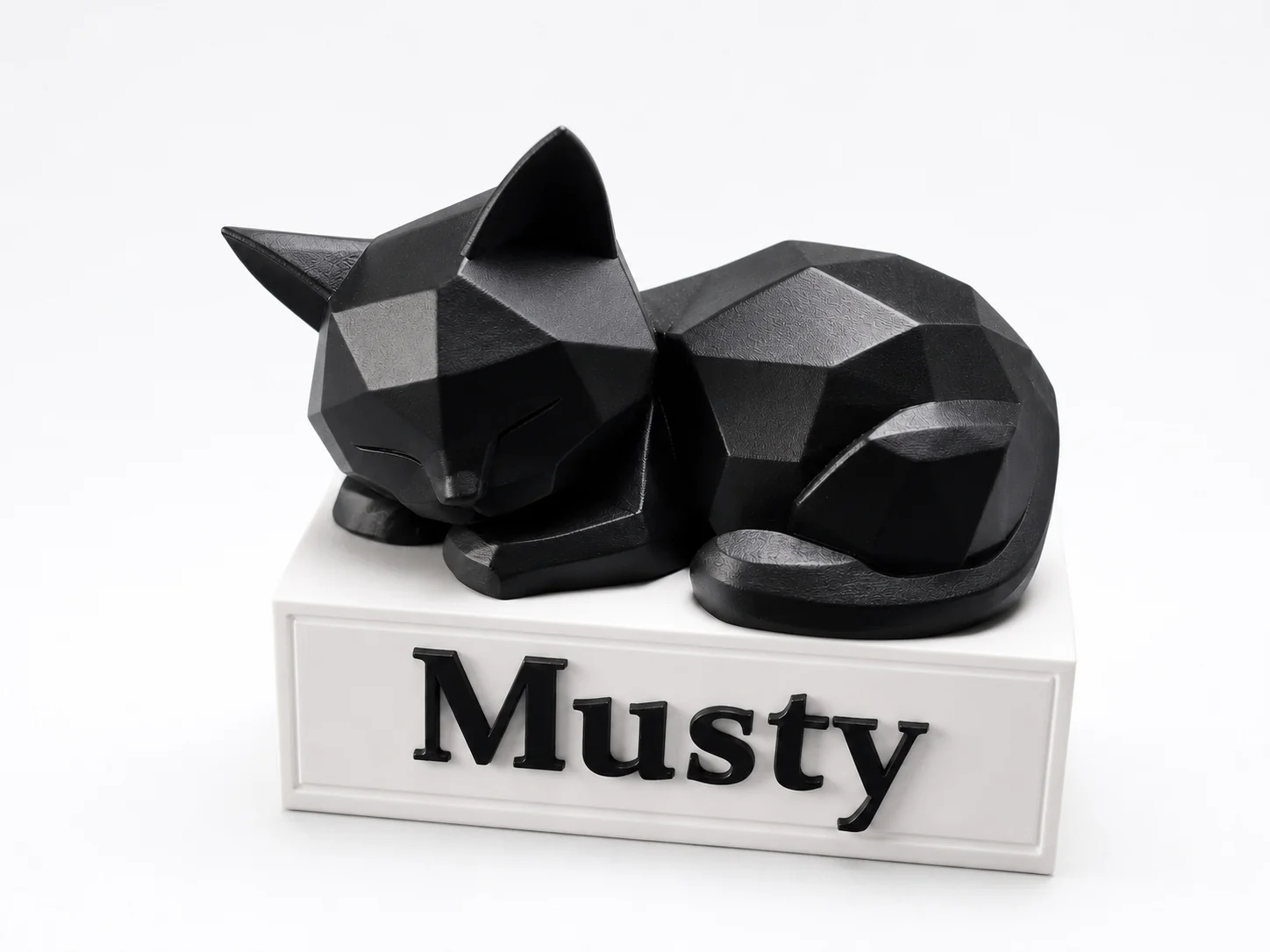 Statuette low-poly d'un chat noir endormi sur un socle blanc gravé du prénom Musty