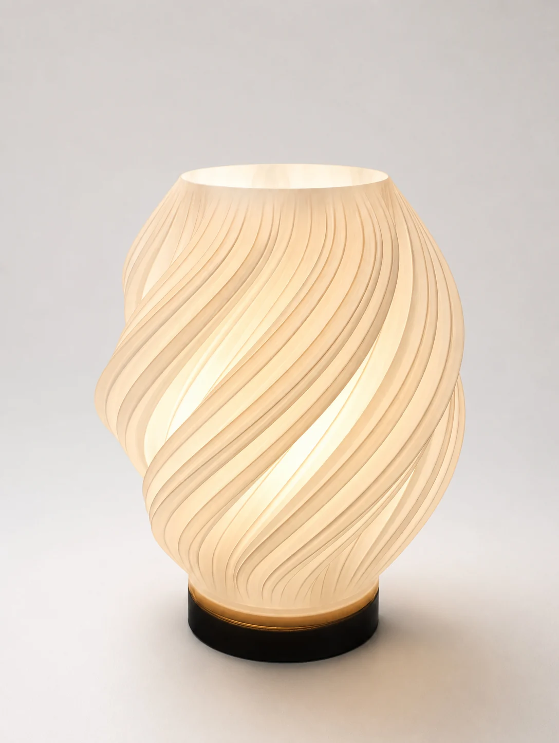 Lampe torsadée imprimée en 3D, allumée, spirales blanches diffusant une lumière chaude