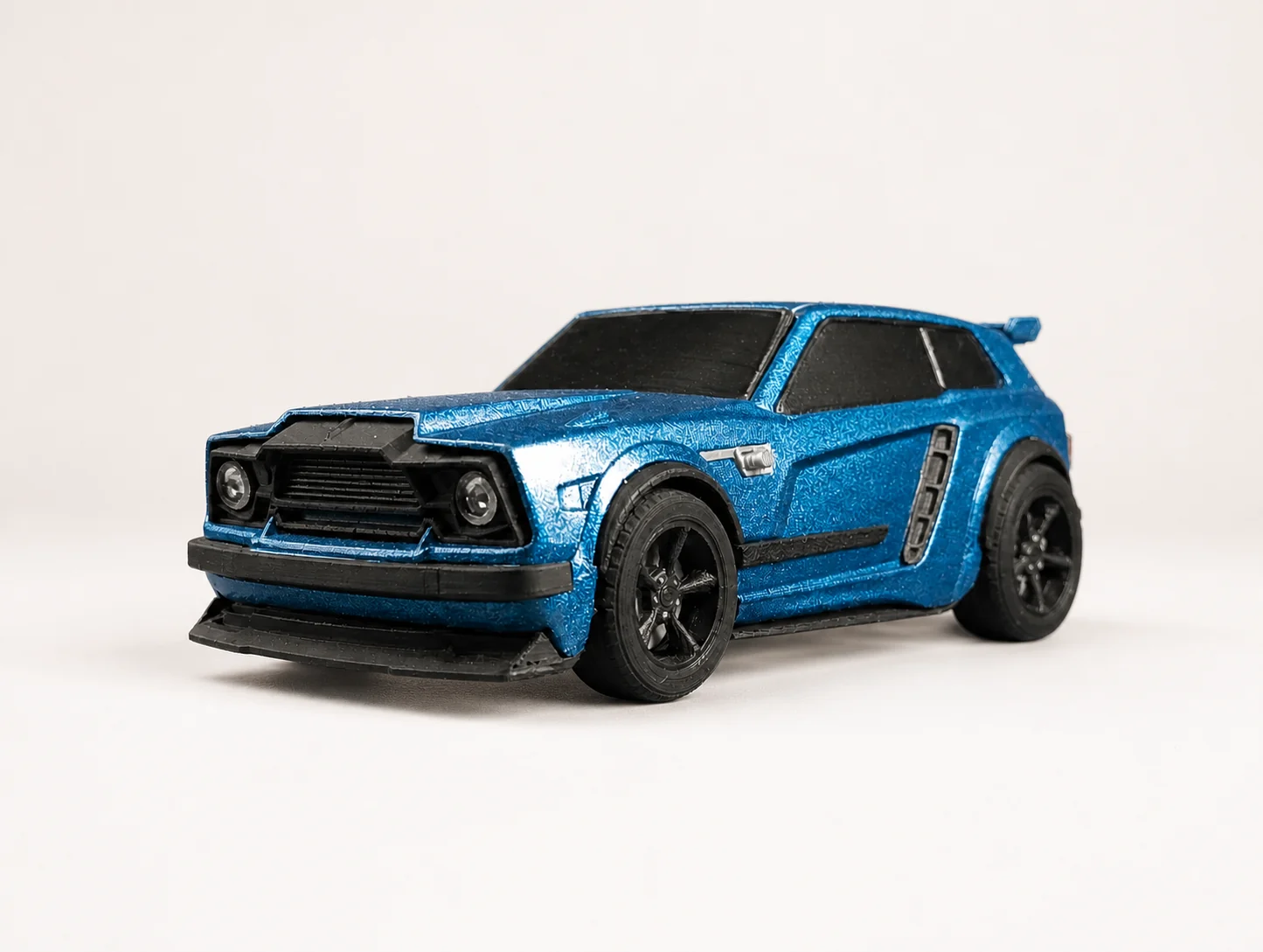 Voiture miniature bleu métallisé imprimée en 3D, vue de trois quarts avant, calandre noire