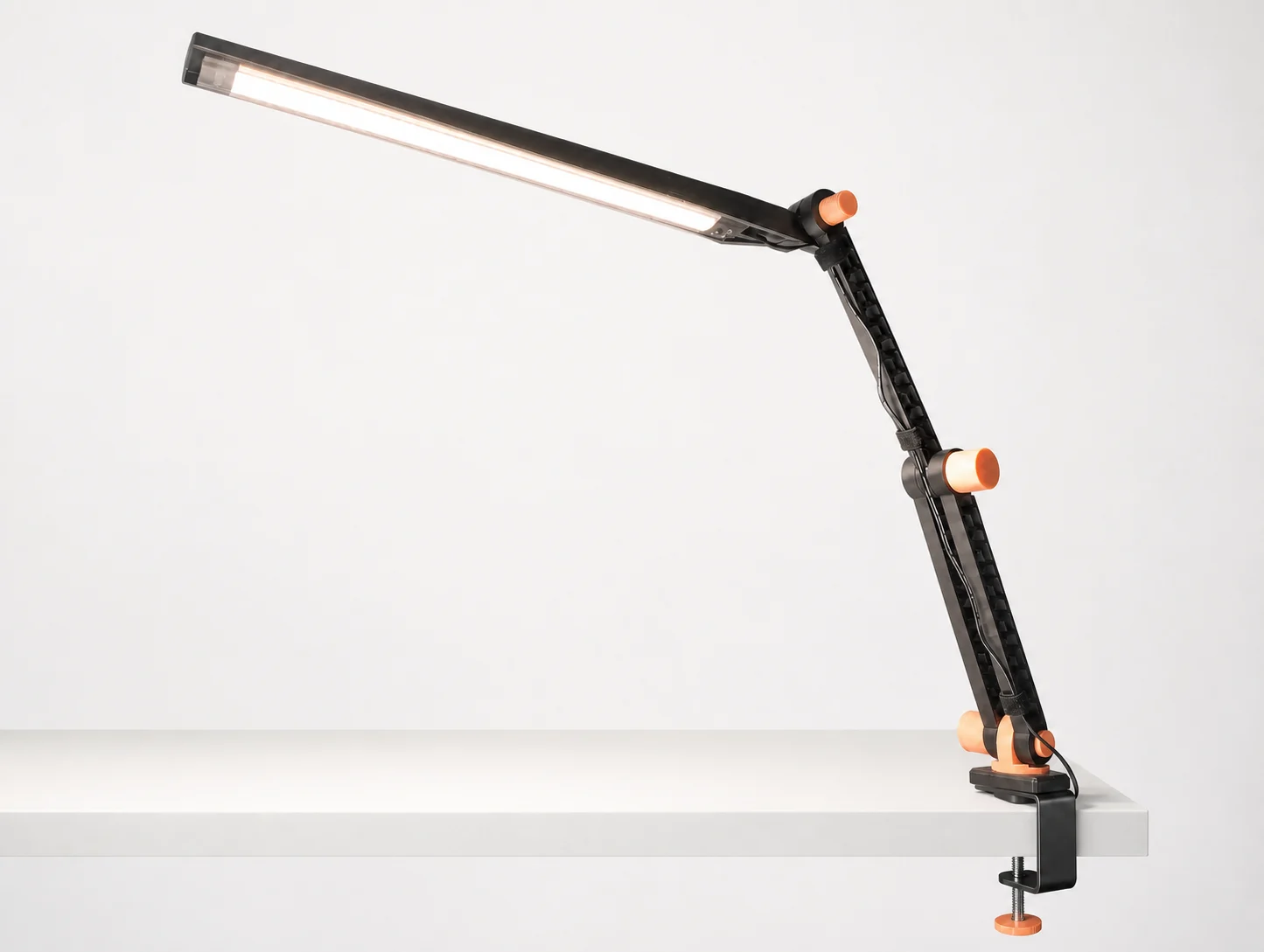 Lampe LED articulée noire imprimée en 3D, fixée au bord d'une table par une pince