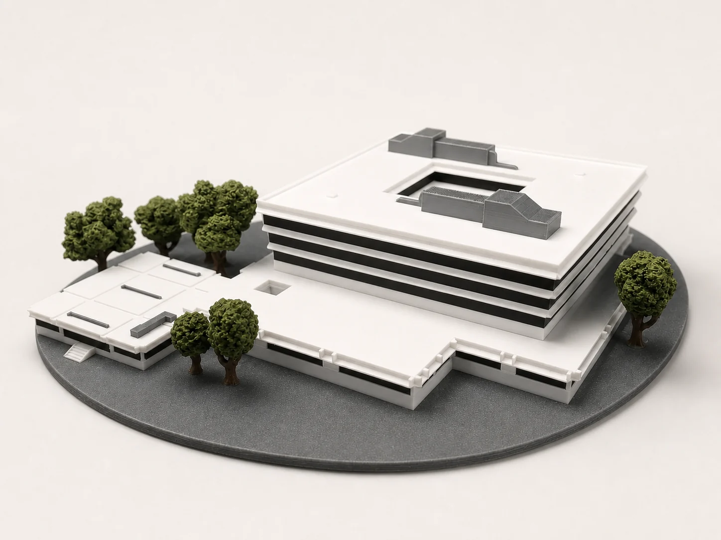 Maquette architecturale imprimée en 3D d'un bâtiment moderne blanc avec arbres miniatures sur socle gris